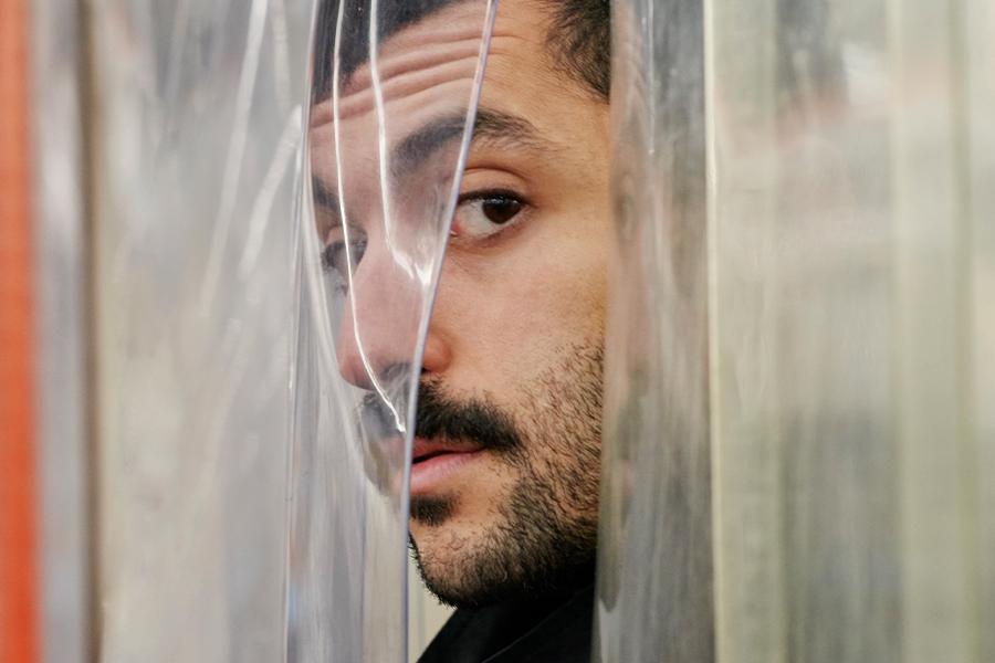 H.Sinno poses behind plastic curtains